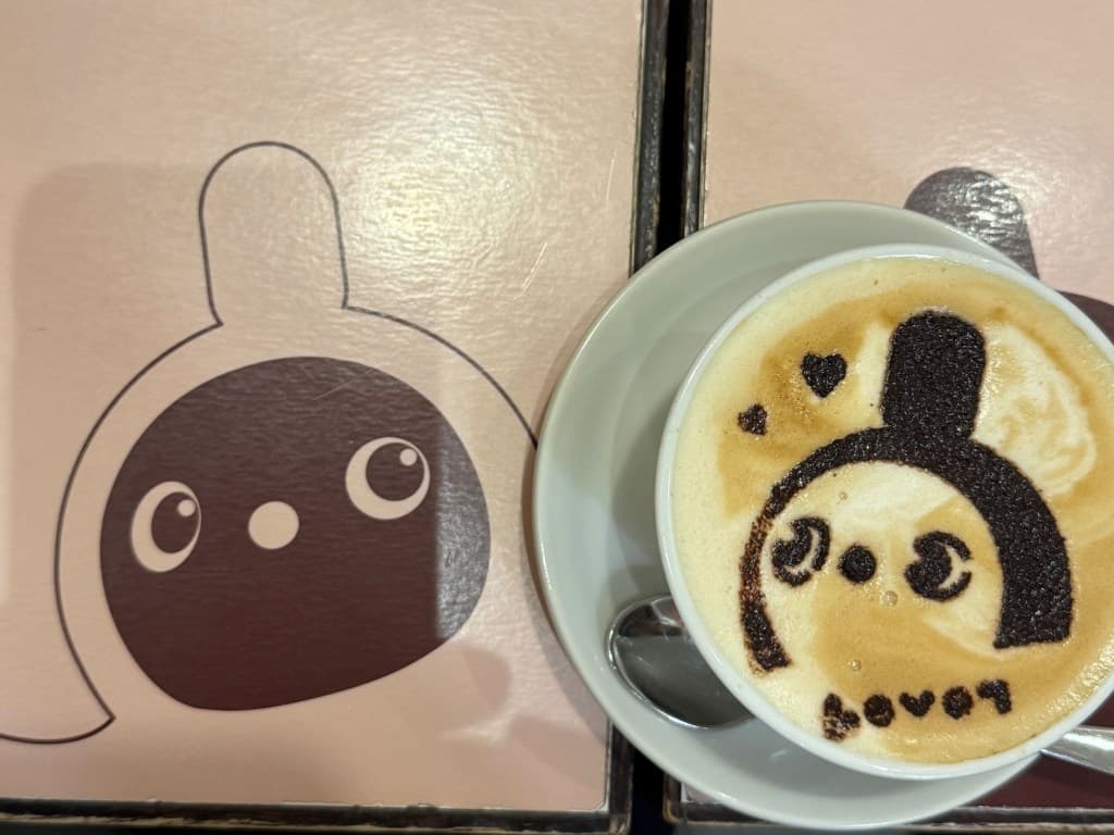 LOVOT カフェで提供されたラテアート。ラテの表面に描かれたLOVOTとテーブルに描かれたLOVOTが並んで写っている。